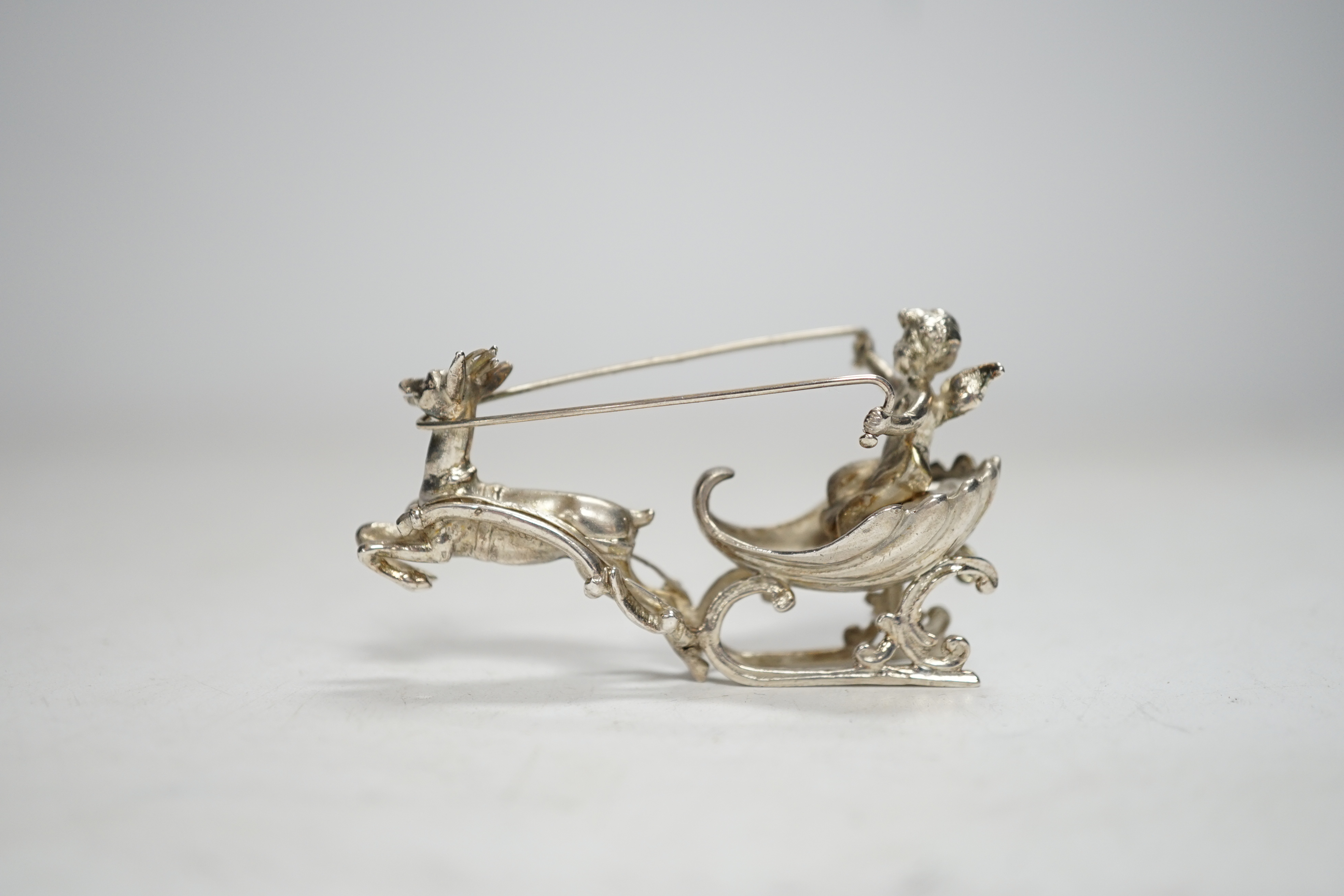 A late 19th century Hanau miniature silver model of a deer pulling a sleigh with cherub, by Berthold Muller, import marks for Chester, 1899, length 64mm.